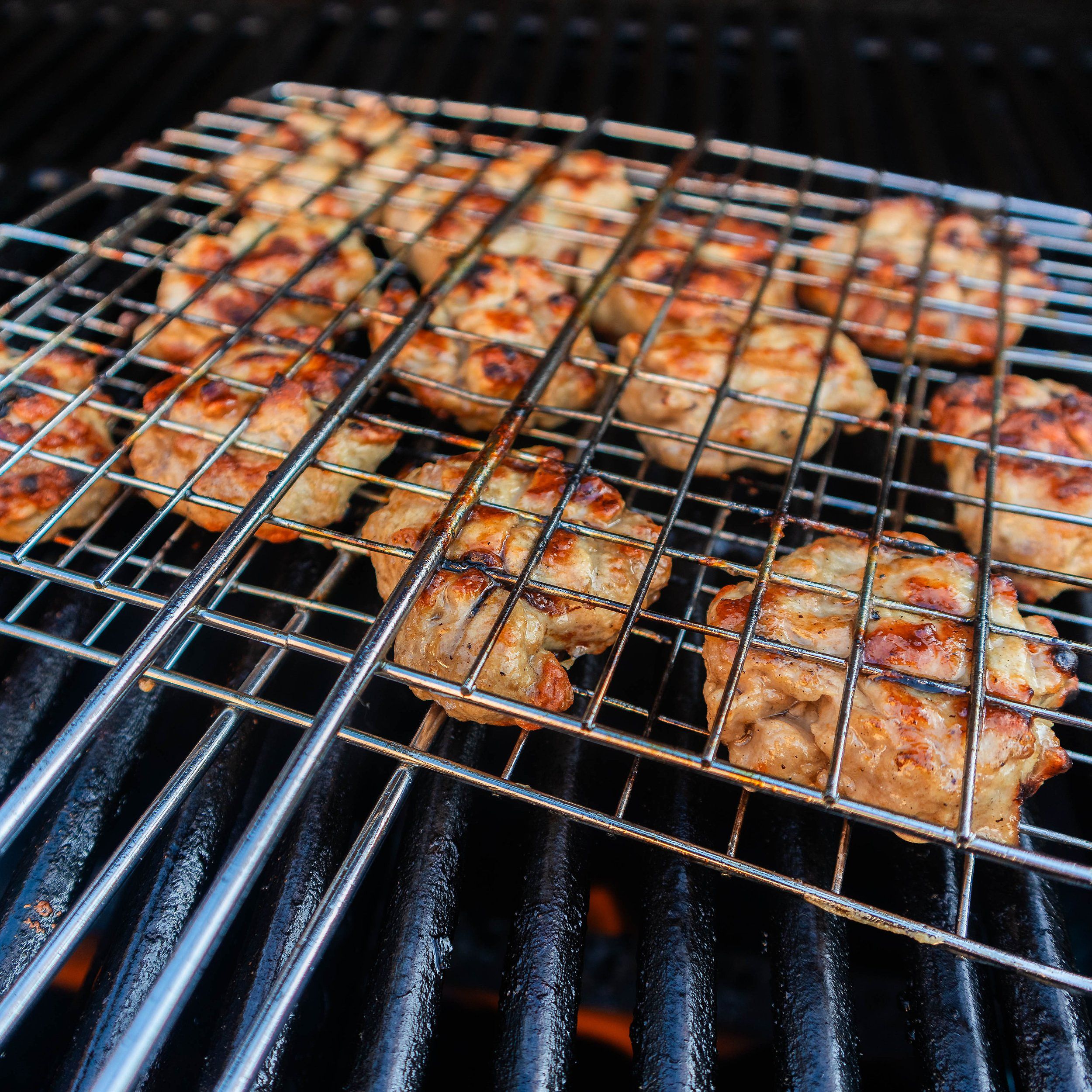 Grilling bun cha pork patties with metal wire basket