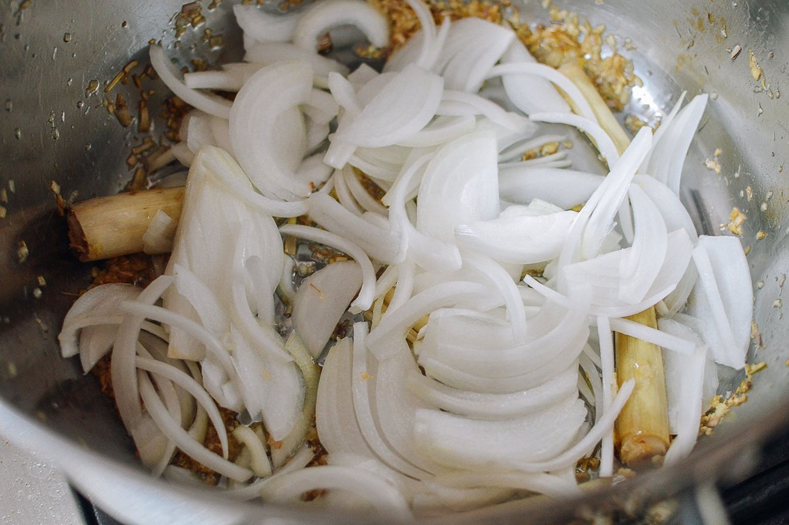 Sliced onion added to lemongrass and ginger