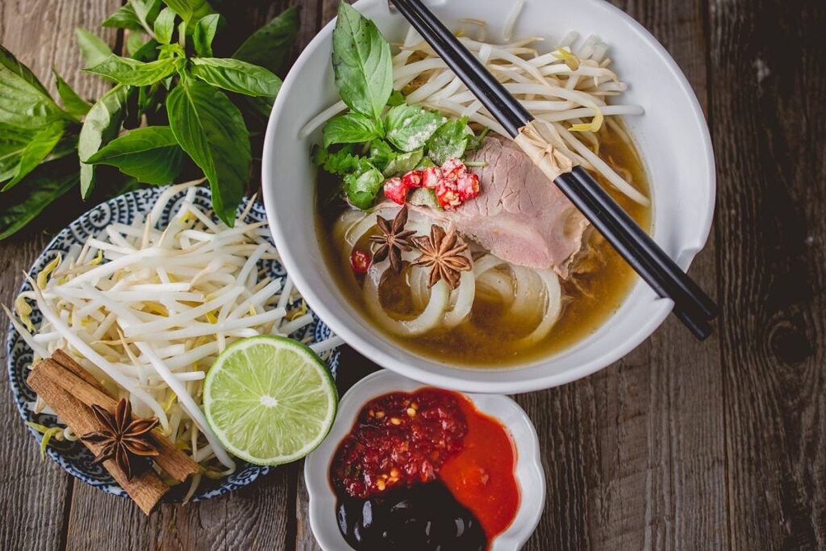 A bowl of pho, showcasing its rich broth and fresh herbs