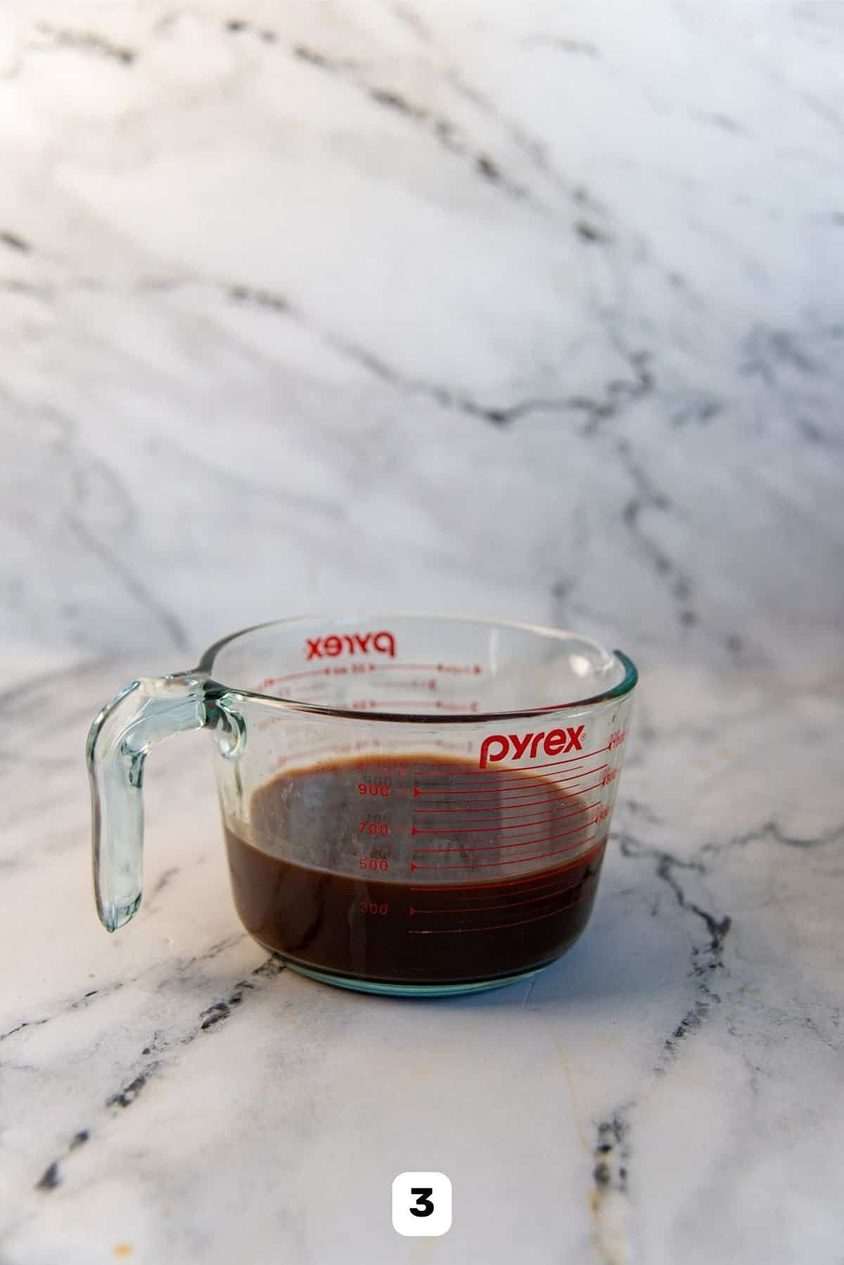 Brewed strong tea after straining, in a glass jug.