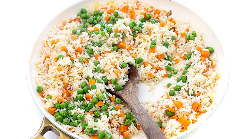 Stirring in peas and rice to large skillet