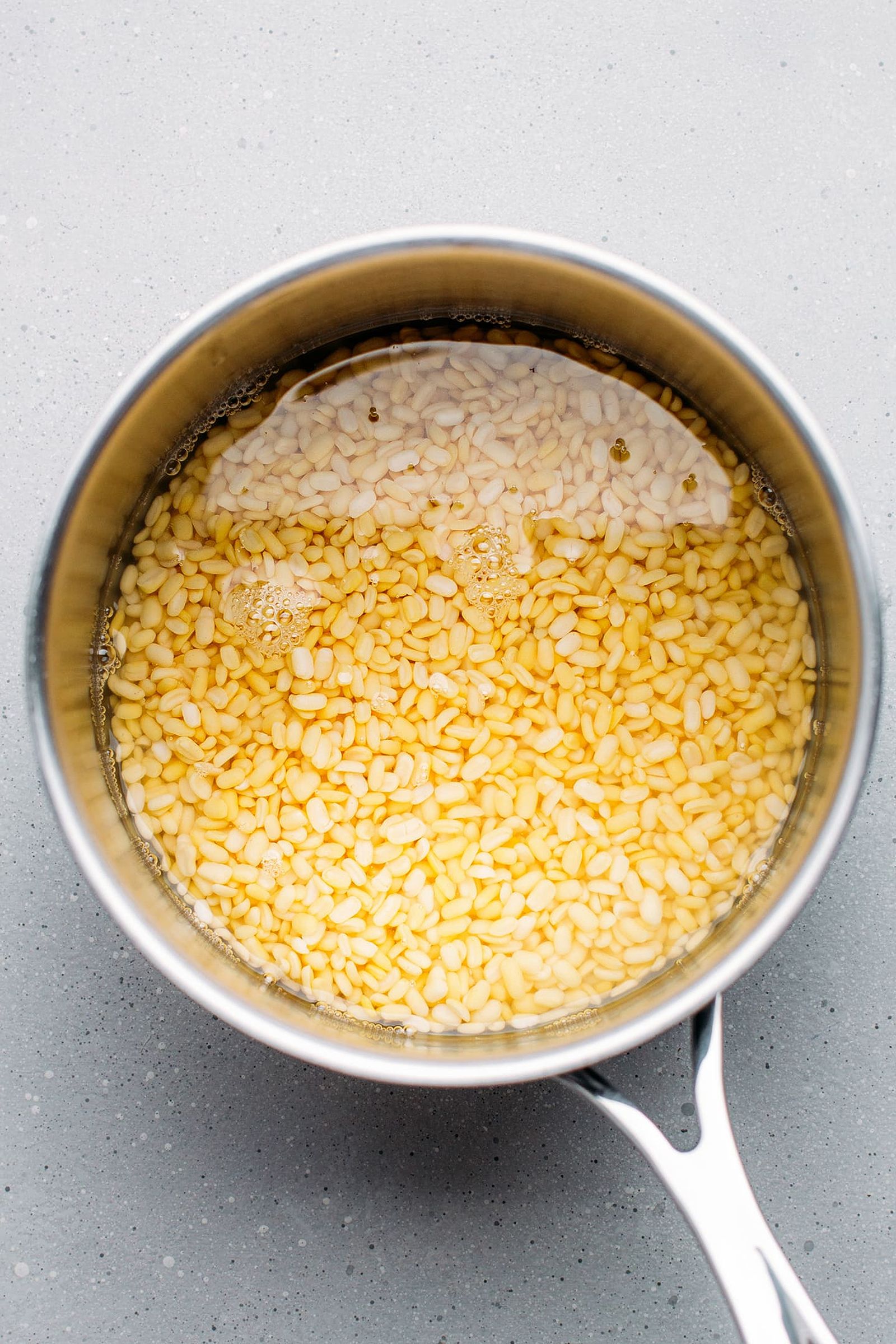 Uncooked yellow mung beans in a saucepan